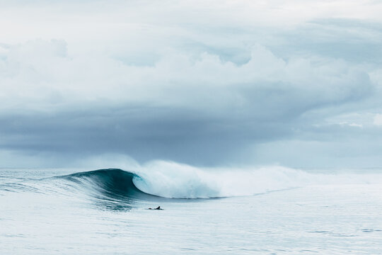 Surfista rema en una ola perfecta en un d&iacute;a de tormenta en Indonesia