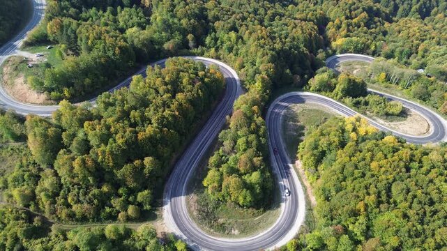 The colors of the tree leaves in the mountains in autumn and the winding, dangerous road. 