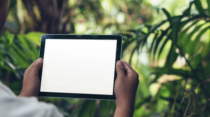Mockup de imagem de homem segurando um tablet com tela em branco na natureza.
