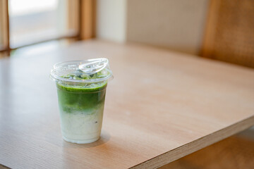 Iced matcha latte drink on a neutral background soft shadows summer drinks, copy space concept.