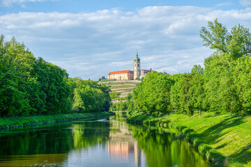 Landscape of Melnik with a calm rive with historic castle with a church tower. The scene is bright...