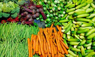 Fresh Colorful Vegetables Displayed at Market Stall - carrots, cucumbers, green beans, broccoli, beets, eggplants
