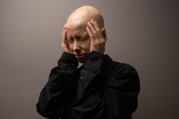 Bald woman in black shirt feeling emotional fatigue, concept of cancer mental health awareness,...