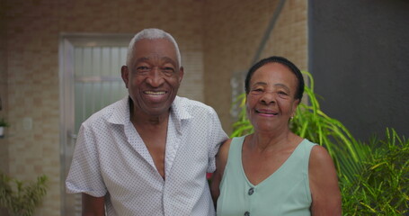 Fototapeta premium Elderly African American couple smiling warmly together, joyful expressions radiating love, unity, and deep connection in an outdoor setting
