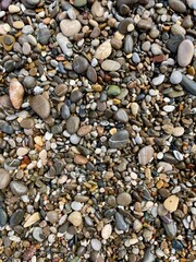 Textured close-up of colorful pebbles on the beach creating a natural mosaic pattern