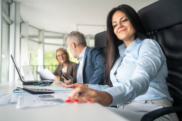 Naklejka premium Multiethnic team discussing business strategy around laptop creative office environment collaboration