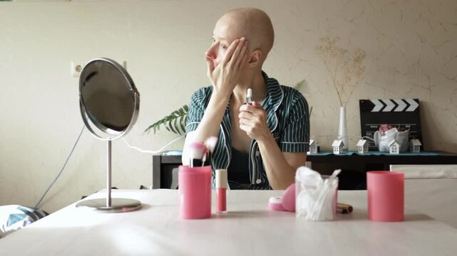 Woman recovering from cancer carefully applies facial serum in front of a mirror, showing gentle beauty and daily skincare for sensitive skin after therapy