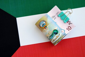 Kuwaiti dinar currency money bills lies on flag close up. The concept of business and investment