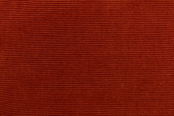 Fototapeta premium Detailed texture of a corduroy fabric in a rich burnt orange, red tone 