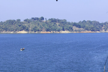 Green Hills and Sparkling Lake under Blue Sky