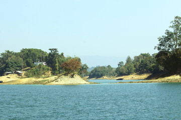 Green Hills and Sparkling Lake under Blue Sky