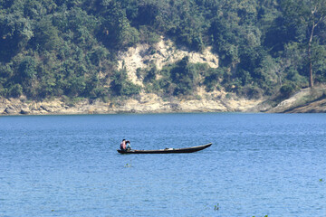 Fisherman on Wooden Boat in Calm River