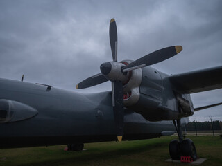 planes under clouds, aircrafts resting beneath overcast skies, large cargo planes parked under cloudy sky overhead, airplanes stationed beneath dense cloud cover during daylight hours