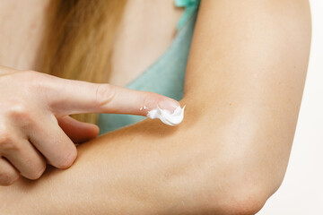 Woman apply moisturizer cream on her body