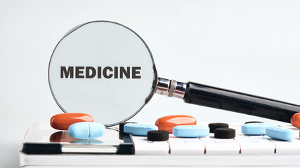 A magnifying glass focuses on the word medicine with colorful pills scattered around a notebook. This scene highlights the importance of attention to health and wellness