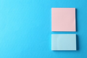 Blank colorful notes on light blue background, top view. Space for text