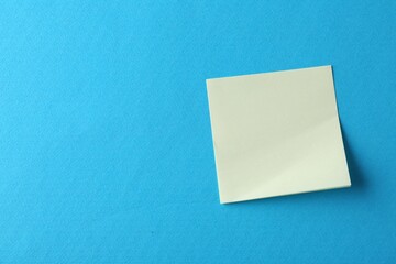 Blank yellow notes on light blue background, top view. Space for text