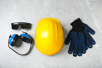 Different safety equipment on light grey marble table, flat lay