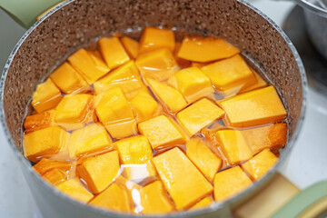 Pieces of ripe pumpkin boiling in pot for porridge preparation, ideal for autumn recipes and healthy cooking content