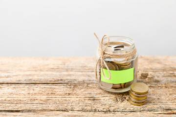 Jar with blank note and money on wooden table against white background. Space for text