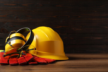 Different safety equipment on wooden table. Space for text