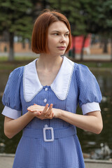 Portrait of a young woman in a blue dress with a white collar