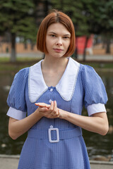 Portrait of a young woman in a blue dress with a white collar