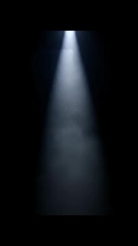 Spotlight beam shining through dark space with floating dust particles creating mysterious dramatic atmosphere in black void