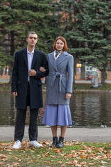 A young couple poses in an autumn park