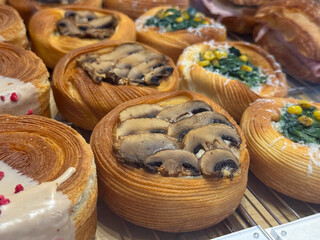 Freshly baked pastries with mushrooms and vegetables in bakery display. Savory flavors, texture, and craftsmanship in gourmet patisserie.