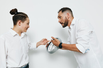 Professional business scene showing a man interacting with a colleague against a plain colored...