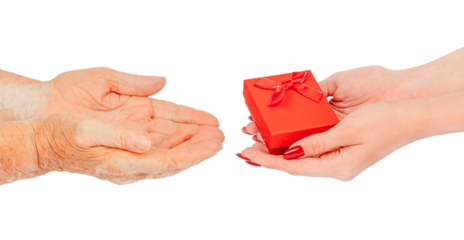 Young female hands offering a small red gift box with a bow to elderly hands waiting to receive it symbol of care, love, kindness, and intergenerational connection,