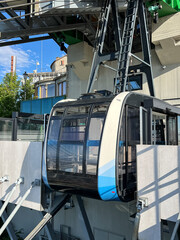 Modern cable car cabin at mountain station under sunny blue sky