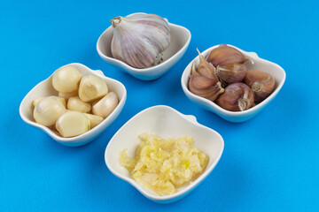 Variety of Garlic Preparations in White Bowls on Blue Background for Culinary Use