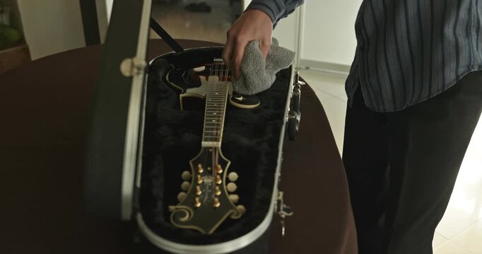 Male Musician Diligently Take Care of Instrument. Wipe Dust from Mandolin 4K 10-bit