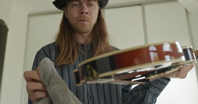 Male Musician Diligently Take Care of Instrument. Wipe Dust from Mandolin 4K 10-bit