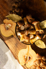 Honey mushrooms with bay leaves and quince on a rustic wooden table