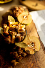 Honey mushrooms with bay leaves and quince on a rustic wooden table