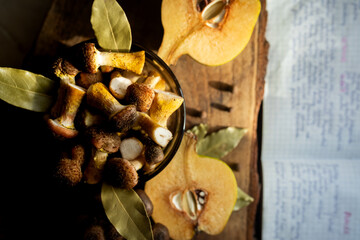 Honey mushrooms with bay leaves and quince on a rustic wooden table
