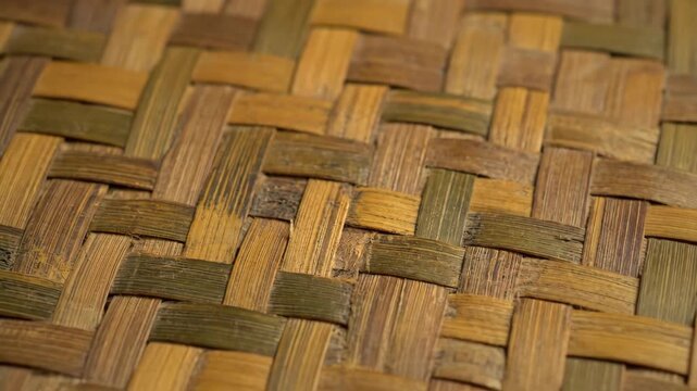 Rustic Bamboo Weave Texture - This close-up shot showcases a vintage, hand-woven bamboo pattern. The rustic texture features alternating strips of aged bamboo in natural brown and green tones.