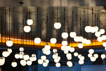 Numerous glowing spherical hanging chandeliers on the ceiling.