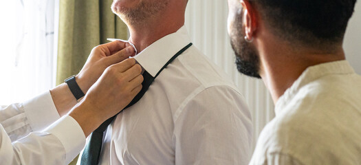 Groom Getting Ready with Best Man Adjusting Tie Before Wedding