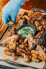 A tray of chicken wings with a dipping sauce