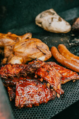 A plate of ribs and chicken is on a grill