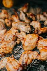 A plate of chicken wings is being cooked on a grill