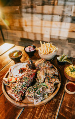 A plate of food with a variety of meats and vegetables, including chicken wings