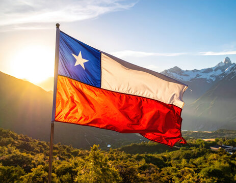 una bandera chilena flameando al viento majestuosamente, al fondo la impresionante cordillera de los andes
