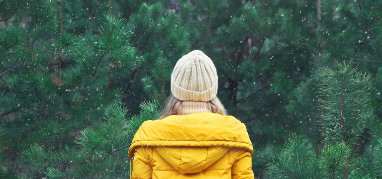Winter day, happy young woman enjoys snow, warm weather against Christmas tree in snowy green forest - Powered by Adobe