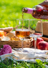 Wine in hands of woman at picnic. Selective focus.