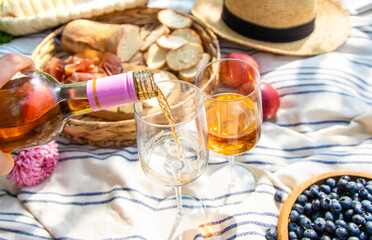 Wine in hands of woman at picnic. Selective focus.